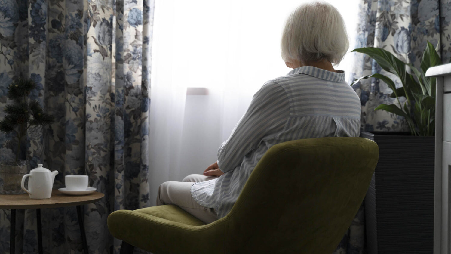 Μόνη ηλικιωμένη γυναίκα κοιτάει από το παράθυρο