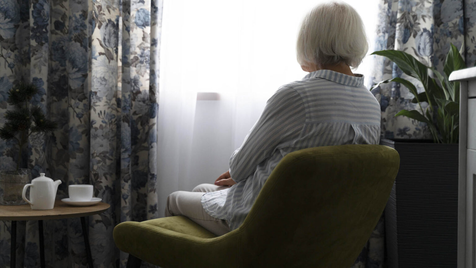 Μόνη ηλικιωμένη γυναίκα κοιτάει από το παράθυρο